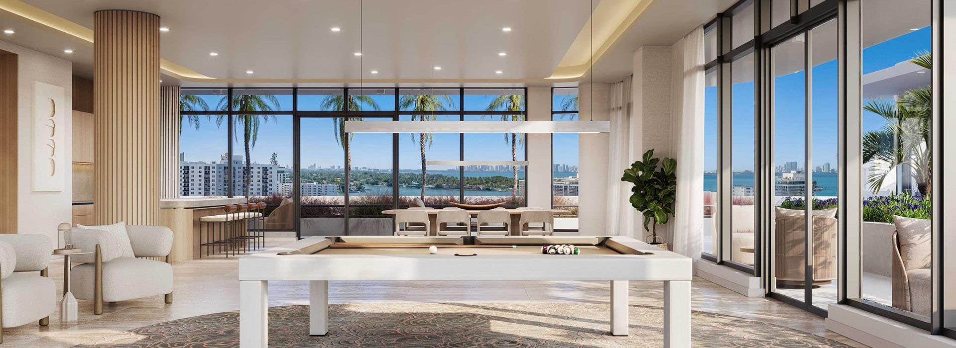 Luxurious open-concept lounge with a pool/billiards table in the foreground, beige seating, and floor-to-ceiling windows overlooking the ocean and palm trees.